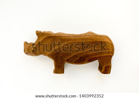 Organic hand made wooden rhino toy isolated on white background. Environment friendly natural stuff. Ecological lifestyle. Baby care and childhood concept. Trendy element for design mock-up.