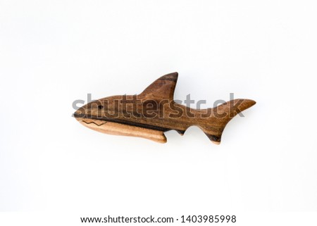 Organic hand made wooden shark toy isolated on white background. Environment friendly natural stuff. Ecological lifestyle. Baby care and childhood concept. Trendy element for design mock-up.