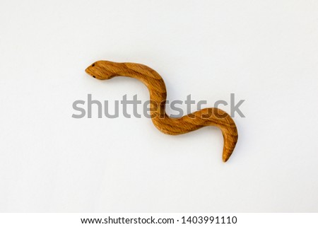 Organic hand made wooden snake toy isolated on white background. Environment friendly natural stuff. Ecological lifestyle. Baby care and childhood concept. Trendy element for design mock-up.