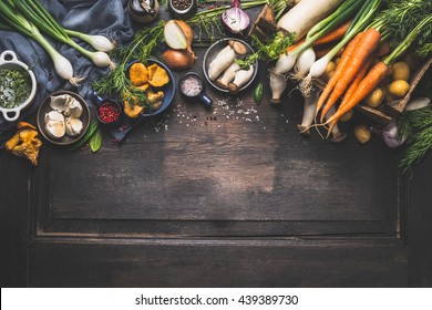Organic harvest Vegetables from garden and  forest mushrooms. Vegetarian ingredients  for cooking on dark rustic wooden background, top view, border