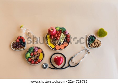 Organic  healthy  food , grains  in  wooden  bowls , medical  stethoscope , two  hearts  shape on pastel  background  for  the  health  concept .
Top  view  and  copy  space  for  use.