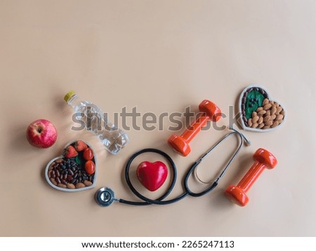 Organic  healthy  food  in  wooden  bowls , medical  stethoscope , red  heart  shape , dumbbells  and  bottled  water  on  pastel  background  for the  health concept . Top  view  and  copy  space .