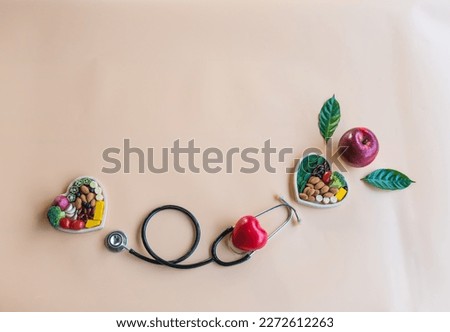Organic  healthy   food  in  wooden  bowls  , medical  stethoscope ,red  heart  shape  and  the  apple  on  pastel  background  or  the  health  concept . Top  view  ad  copy  space  for  use.