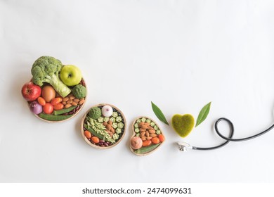 Organic  healthy  food  in  wooden  bowls,medical  stethoscope  and green  heart  shape  on  white  background  for  the  health  concept.Top  view