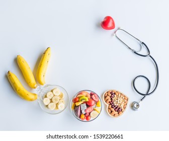 Organic  healthy  fruits  salad  in  glass  bowl,bananas,stethoscope  and  red  heart  shape  on  white  background  for  creative  healthcare  concept - Powered by Shutterstock