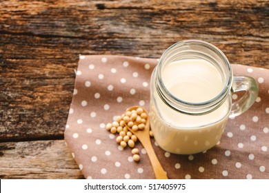  organic homemade soy milk  in glass and soy bean on wood table background. 