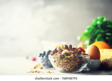 Organic ingredients for healthy lunch - berries, milk, egg, oatmeal on grey concrete background. Copy space. Healthy breakfast concept.