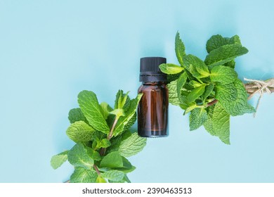 Organic mint essential oil in dark glass bottle with fresh peppermint leaves bunch on the light blue background, top view, copy space. Refreshing essential oil, plant extract, alternative medicine
 - Powered by Shutterstock