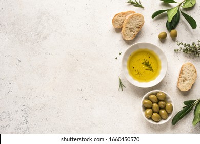 Organic Olive Oil in bowl with green olives, rosemary and ciabatta bread on white background ,top view, copy space. Healthy mediterranean food concept. - Powered by Shutterstock