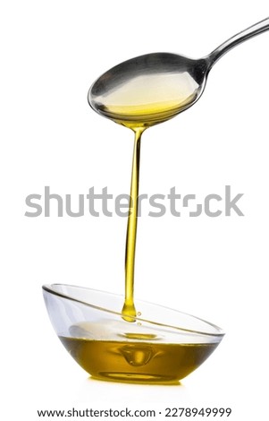 Organic olive oil pouring from the spoon
