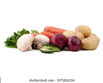 Organic pile of potatoes, carrots, mushrooms, greens, onion and spicy pepper isolated on a white background. Fresh harvest concept