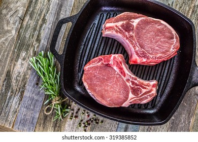 Organic Pork Lion Chops Of Thick Cut On Cast Iron Frying Pan.