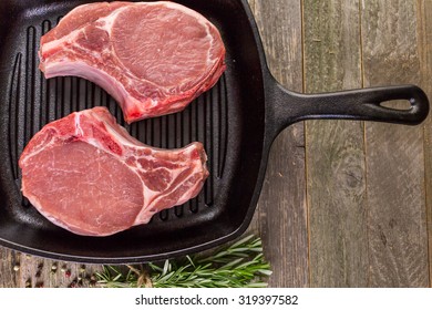 Organic Pork Lion Chops Of Thick Cut On Cast Iron Frying Pan.