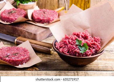 Organic Raw Ground Beef Meat And Burger Steak Cutlets Ready To Prepare On Rustic Table 