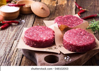 Organic Raw Ground Beef, Round Patties For Making Homemade Burger On Wooden Cutting Board