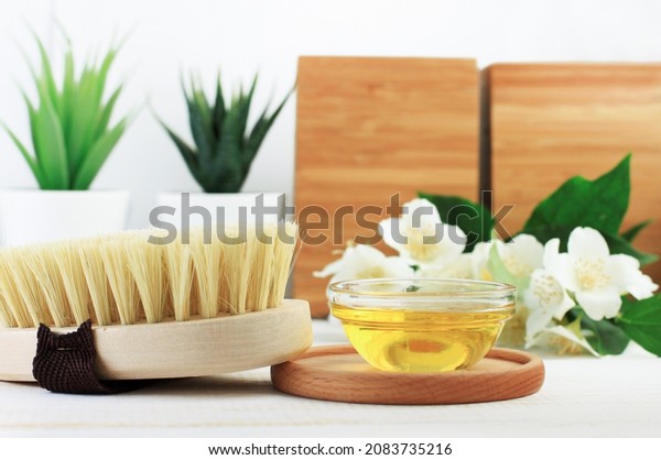 Organic spa exfoliation, body care brush from
natural sisal bristle and bowl of oil for skincare. Homemade body
cleansing and beauty treatment with dry self massage and olive oil.
Wooden, green, white