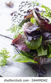 Organic Spring Mix Green Leaves For Salad On Wooden Table