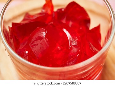 Organic Strawberry Gelatin Snack Is Served In A Small Glass Cup And Set On A Bamboo Plate Over A Pink Napkin