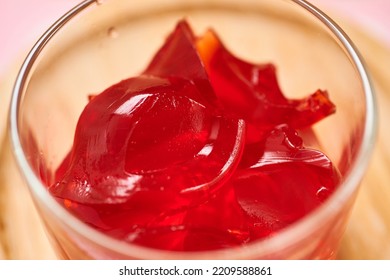 Organic Strawberry Gelatin Snack Is Served In A Small Glass Cup And Set On A Bamboo Plate Over A Pink Napkin