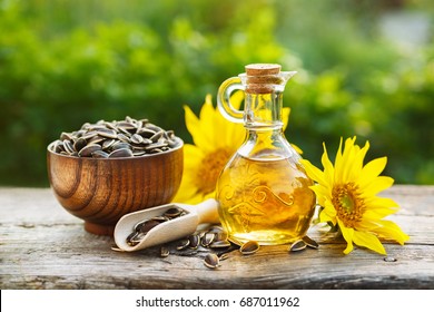 Organic sunflower oil in a small glass jar with sunflower seeds and fresh flowers. Outdoors