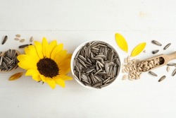 Organic Sunflower Seeds, Scoop And Bright Flower On White Wooden Table, Flat Lay