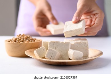 Organic tofu on biodegradable plate with hand prepare tofu for cooking, Vegan food ingredients in Asian cuisine, plant based - Shutterstock ID 2106527387