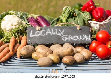 Organic vegetables on a stand at a farmers market with a sign reading locally grown - Powered by Shutterstock