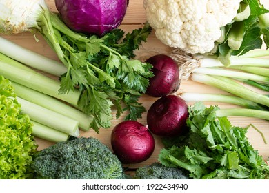organic vegetables, purple onion, celery, leek, broccoli, cauliflower are on the table.