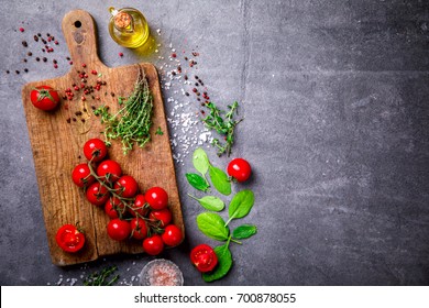 Organic vegetarian ingredients, olive oil and seasoning on rustic wooden cutting board over dark vintage background with space for text.Healthy food, or diet nutrition concept.Fresh Vegetables