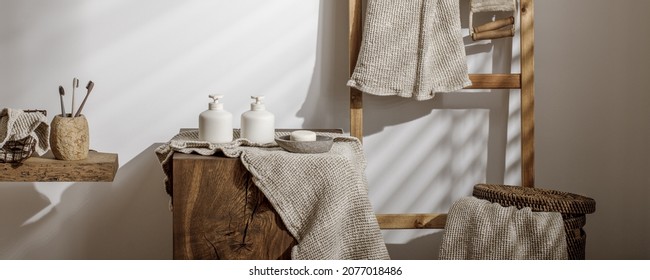 Organic waffle linen towels, bathroom zero waste accessories on solid oak stump in modern bathroom interior. Daily body care, spa and wellness zero waste bathroom concept