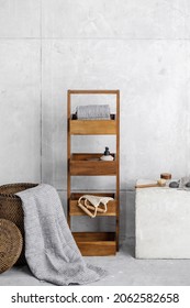 Organic Waffle Linen Towels In Rattan Basket, Wooden Storage Unit, Bathroom Accessories In Grey Shades In Contemporary Bathroom Interior. Daily Body Care, Spa And Wellness Zero Waste Bathroom Concept