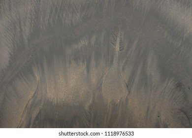 Organic water patterns on the sand at the beach