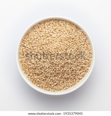 Organic White Sesame seeds(Sesamum indicum) or white Til with shell in white ceramic bowl