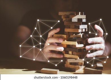 organization ideas concept with hand pull out block of wooden piece from stack strategy and risk concept - Shutterstock ID 1060198448