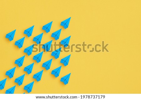 Organization, Leadership and Teamwork concepts, Blue paper plane group flying with arrow on yellow background