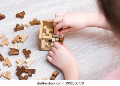 Organization and order. The child folds the wooden puzzle pieces into a folding mold. Leisure for children