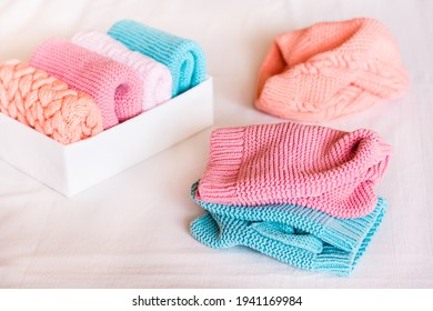 Organization and order. Knitted clothes are in disarray next to a box of neatly folded items