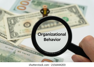Organizational Behavior.Magnifying glass showing the words.Background of banknotes and coins.basic concepts of finance.Business theme.Financial terms. - Shutterstock ID 2156444203
