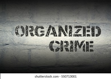 Organized Crime Stencil Print On The Grunge White Brick Wall