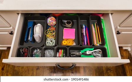 Organized Desk Drawer With Office Supplies In Bins