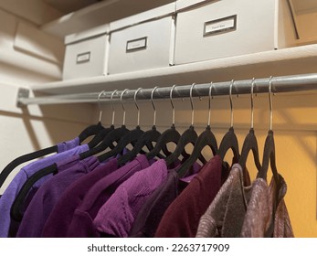 Organized home closet with velvet hangers and storage bins