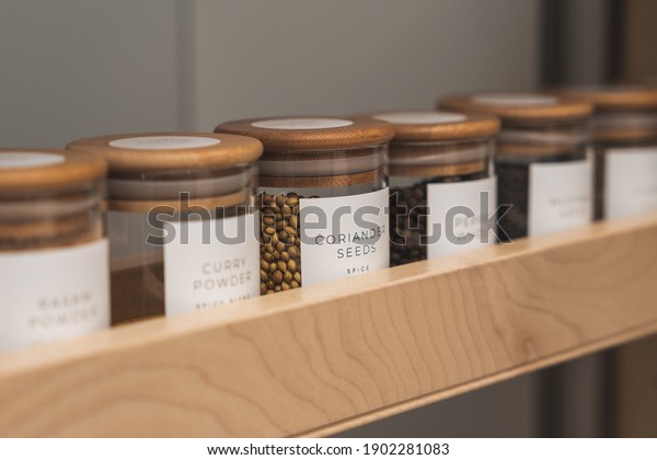 Organized, labeled food pantry in kitchen with\
spices, grains, flours, and\
rice