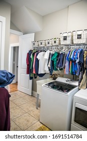 An Organized Laundry Room With Many Clean Shirts Being Hung To Dry Above A Washer And Dryer