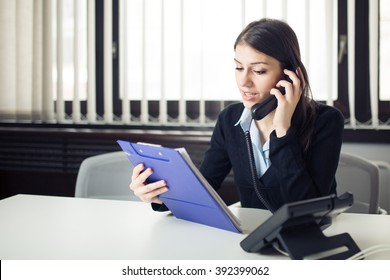 Organized Responsible Office Worker Business Woman Giving Instructions Via Phone Call.Looking Confused Checking Notes And Paperwork.Manager Solving Mistake.Disputes,problems,Complaint,grievances