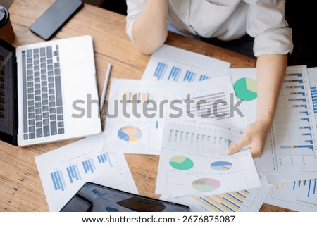 Organized stack of business documents and paperwork on office desk, representing planning, financial analysis, management, efficiency, responsibility, and deadline-focused professionalism.