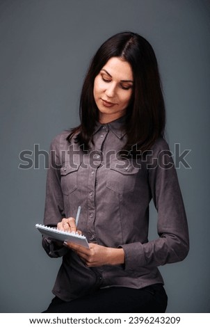 An Organized Woman Capturing Thoughts on Her Trusty Clipboard. A woman holding a clipboard and writing on it