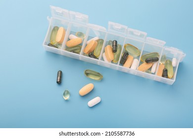 Organizer for pills, vitamins and dietary supplements on a light blue background. Health maintenance concept - Shutterstock ID 2105587736