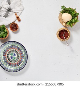 Oriental food background with empty uzbek plate and spices. Eastern cuisine background with copy space. Flat lay in eastern style with traditional dishes and fresh herbs. Uzbek food menu