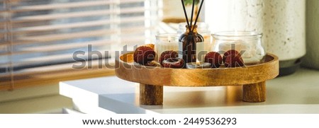 Oriental interior, Bali, Thai vibes banner. Sweet home perfume with tropical exotic fruits. Reed diffuser on wooden tray in a bedroom. Burning candles, atmosphere of relaxation, detention, meditation