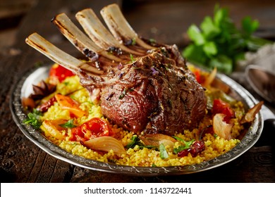 Oriental rack of lamb with saffron rice and roasted vegetables marinated and seasoned with spices and fresh herbs served on a platter - Powered by Shutterstock